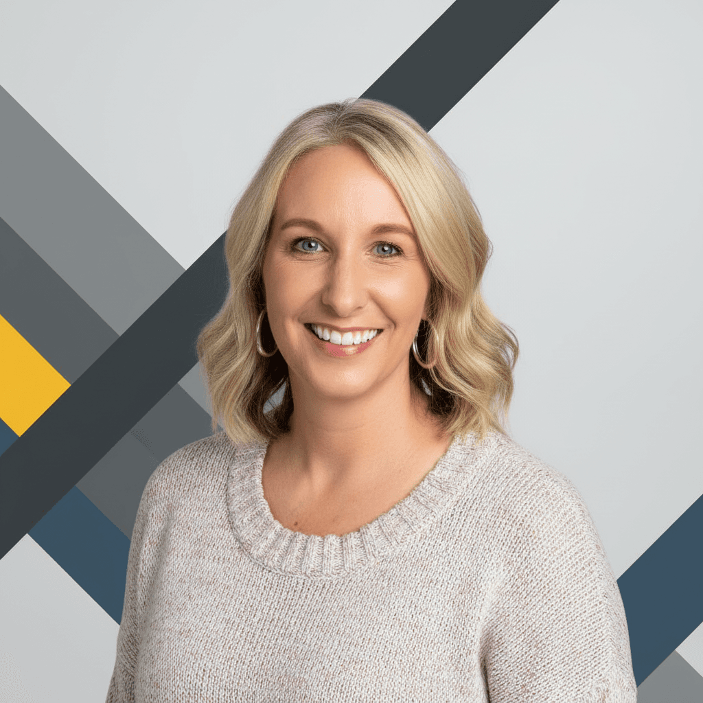 Blonde woman smiling, wearing a beige sweater and hoop earrings, against a grey geometric backdrop.